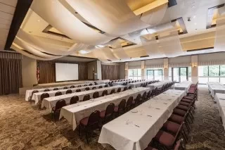 a large room with tables and chairs and a projector screen