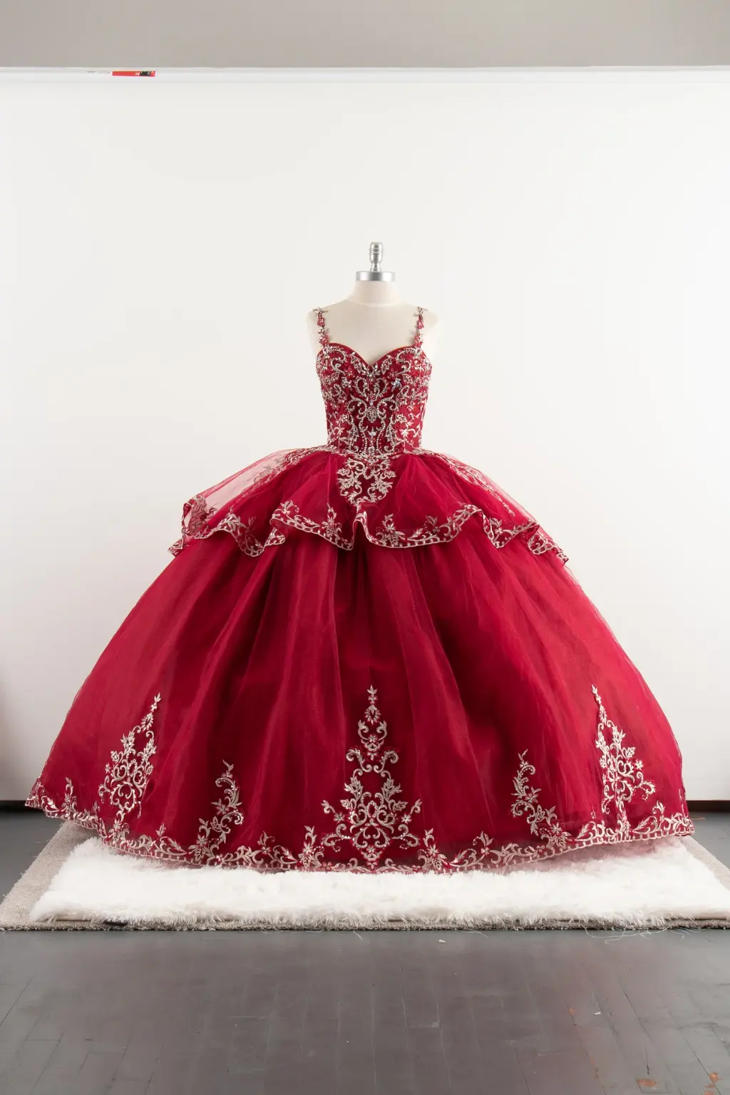 Red sleeveless quinceañera dress with open back, floral straps, and voluminous ball gown skirt with lace appliqués -1