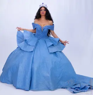 A custom blue quinceañera dress with off-the-shoulder neckline, sweetheart bodice, and ruffled ball gown skirt with a flowing train